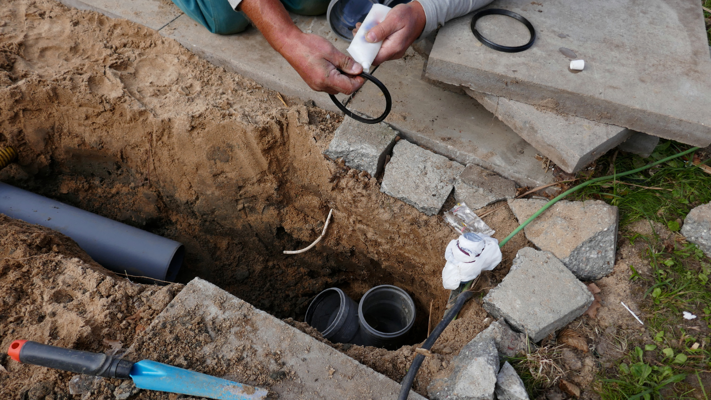 A man holding a pair of scissors over a hole in the ground